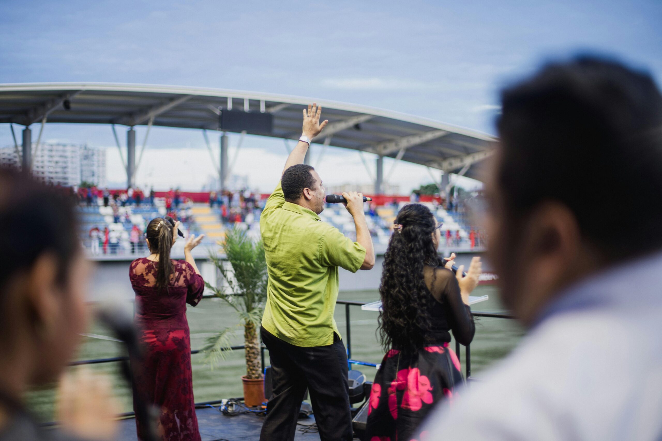 Energetic live music performance at an outdoor stadium with a diverse group of performers.